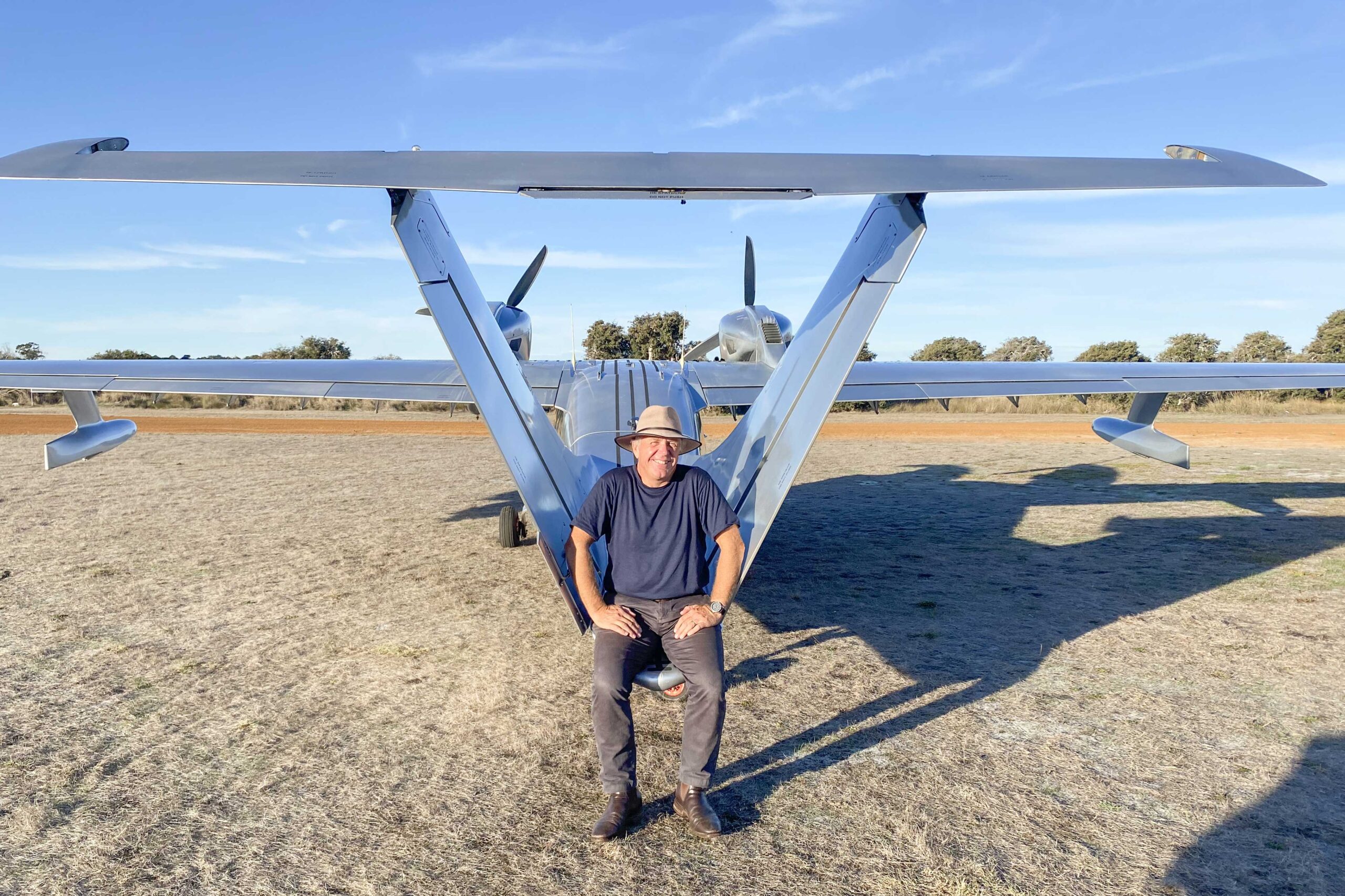 Man sitting on the tail of his seaplane.